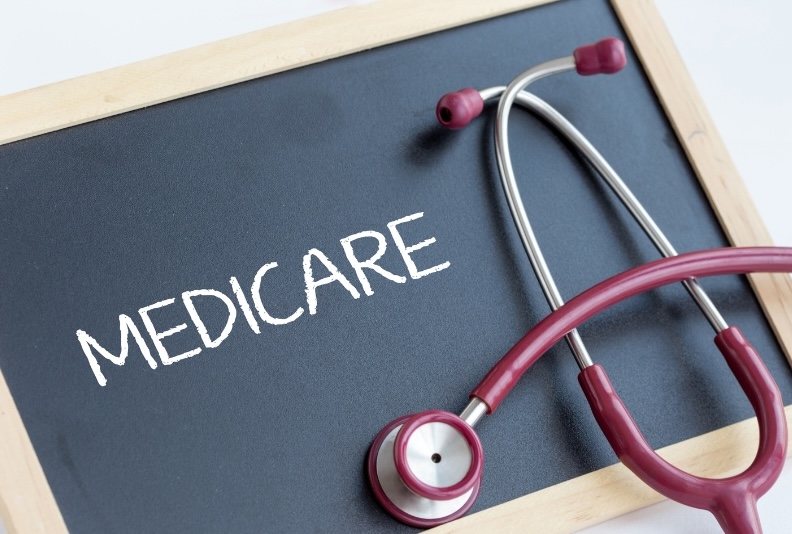 Alt text: A red stethoscope resting on a chalkboard that reads "MEDICARE," illustrating the importance of planning for healthcare costs and sign-up deadlines.